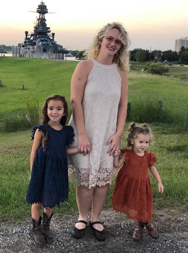 Tiffany Kohen standing with her two daughters at a ship yard.