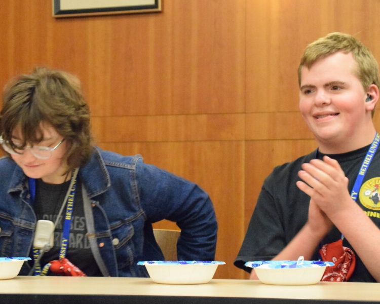 Two young adults sit down together for activity.