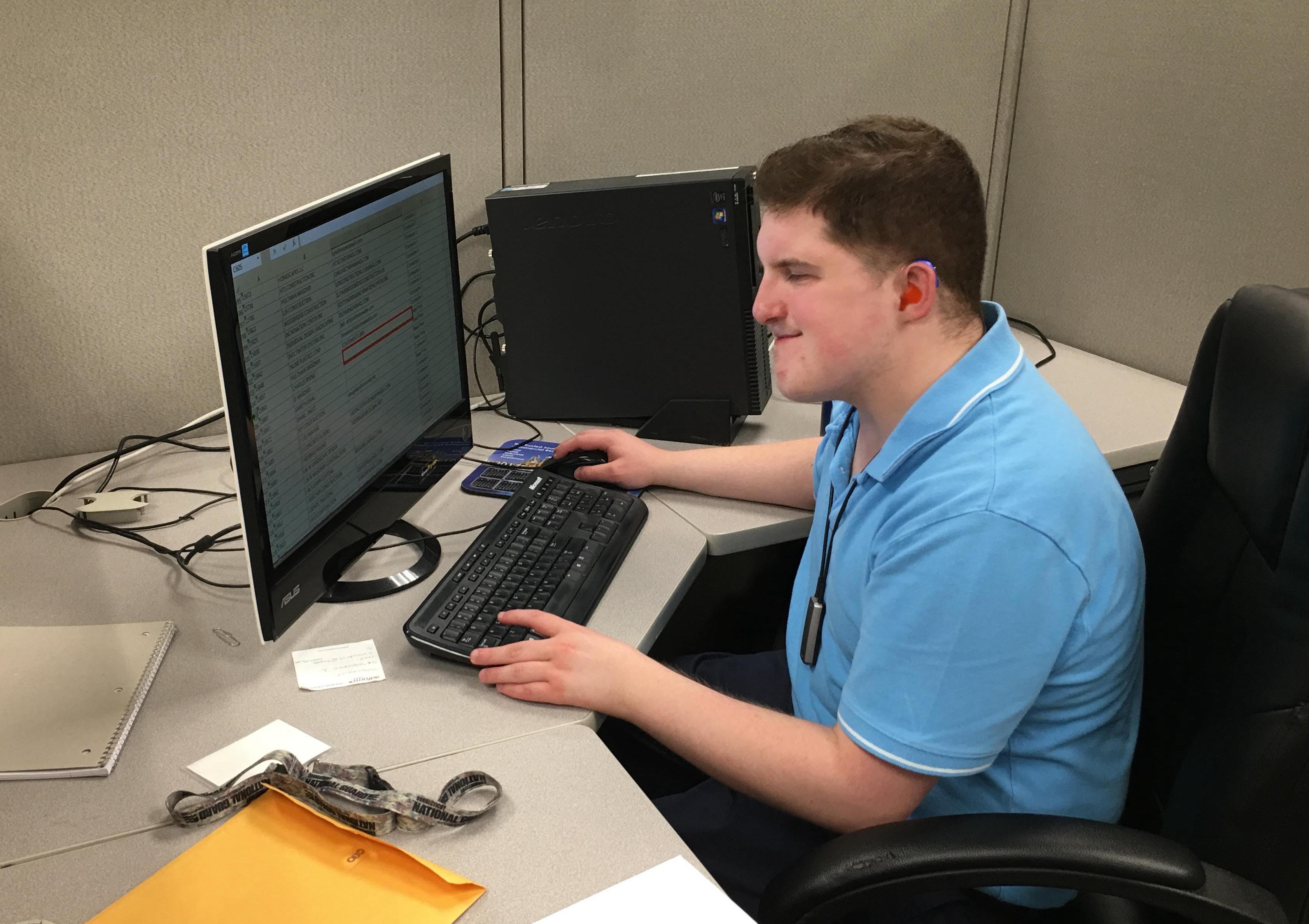 Alex sitting at a desk with computer.