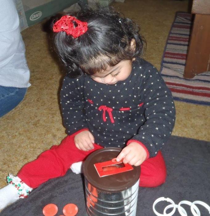 A child places a disc into a slot in a can.