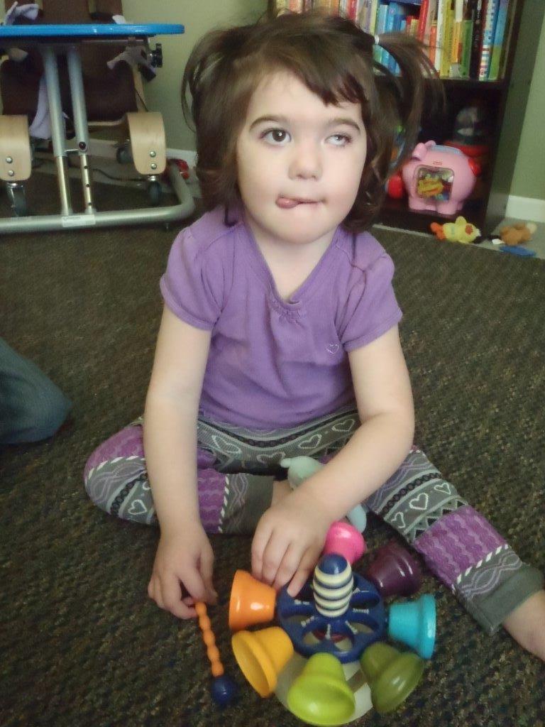 A child plays with a bell toy.