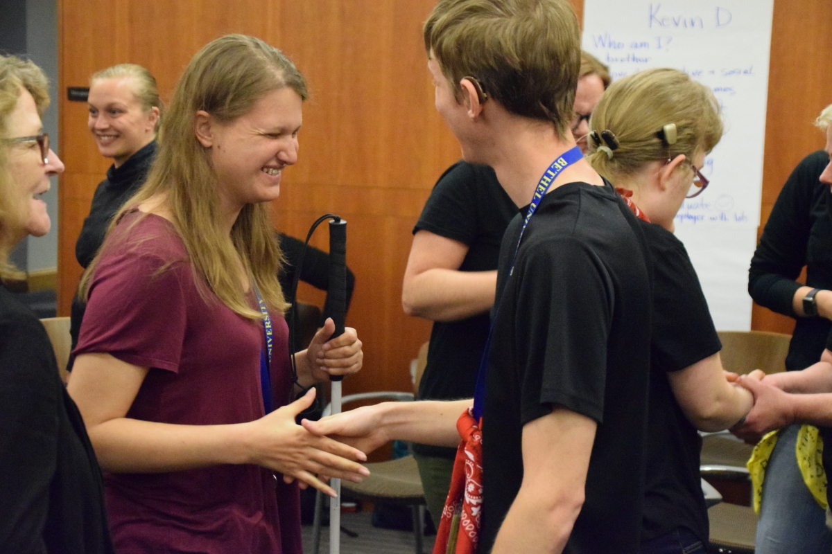 Two young adults shaking hands.