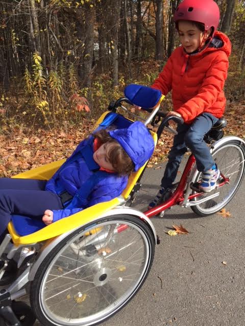 Jack and grace riding an accessible bike.