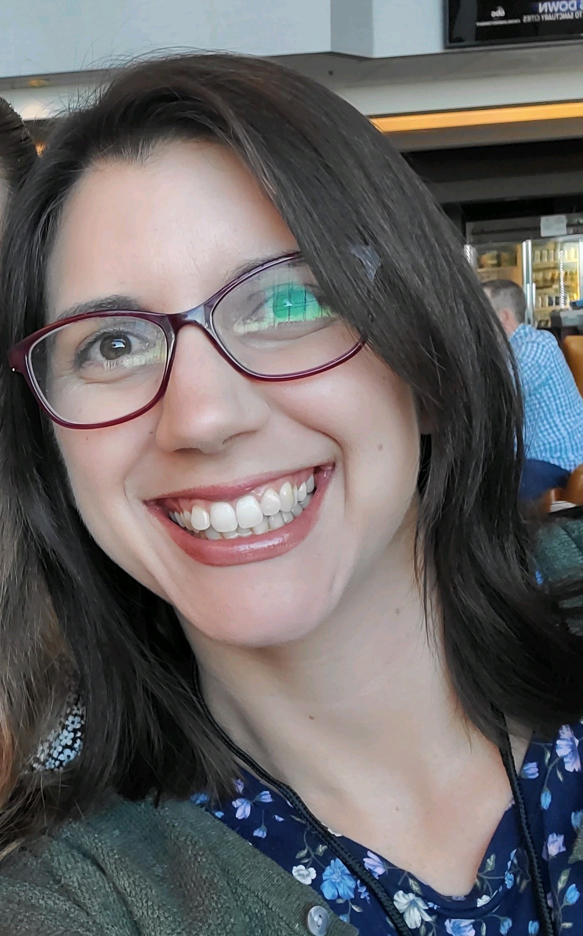 Smiling woman with long brown hair and glasses