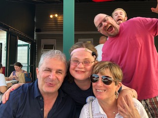 A young adult woman who is deaf-blind posing with family members.