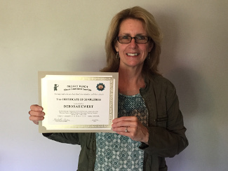 A women holding a certificate.