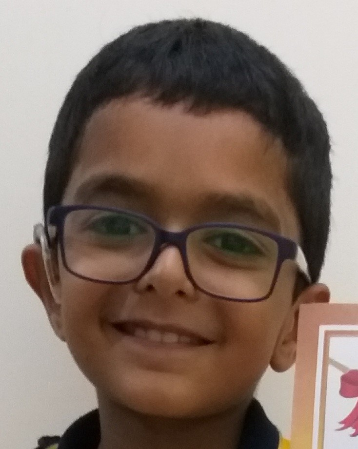 Young boy smiling with glasses.