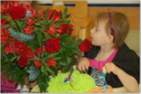 child smelling flowers