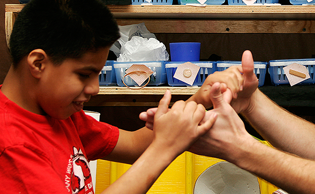 a boy tactile signing with an adults hand