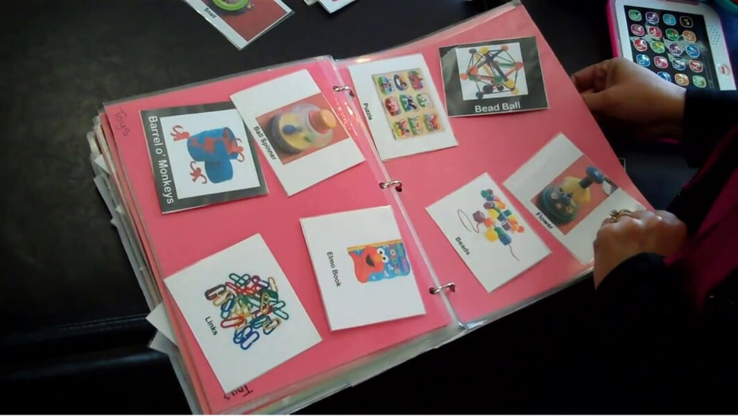 An open binder with pictures of activity choices.